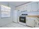 Bright kitchen featuring white appliances, white cabinets, and a window for natural light at 11511 113Th St # 33D, Largo, FL 33778