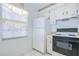 Kitchen with white appliances, white cabinets, and a window providing natural light at 11511 113Th St # 33D, Largo, FL 33778