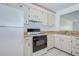Kitchen with white cabinets, laminate countertops, and a sink overlooking the living area at 11511 113Th St # 33D, Largo, FL 33778