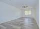 Bright living room features wood-look floors, a ceiling fan, and a large window for natural light at 11511 113Th St # 33D, Largo, FL 33778