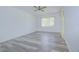 Bright living room features wood-look floors, a ceiling fan, and a large window for natural light at 11511 113Th St # 33D, Largo, FL 33778