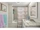 Modern bathroom featuring a tub with shower, gray tiled walls, and a stylish vanity with marble countertop at 120 W Sligh Ave, Tampa, FL 33604
