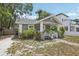 Charming gray home featuring a cozy front porch and beautiful landscaping at 120 W Sligh Ave, Tampa, FL 33604