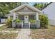 Charming front of house featuring a welcoming porch, gray brick, and well-maintained landscaping at 120 W Sligh Ave, Tampa, FL 33604