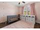 Charming Bedroom with a crib and pink accents and stylish storage units at 12415 Hitching St, Odessa, FL 33556