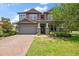 Charming two-story home with a brick driveway, manicured lawn, and stone pillar accents at 12415 Hitching St, Odessa, FL 33556