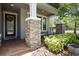 Inviting front porch with stone pillars and neutral chairs for relaxing in front of the home at 12415 Hitching St, Odessa, FL 33556