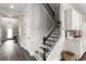 Inviting hallway featuring dark hardwood floors, white trim, and staircase with decorative iron railing at 12415 Hitching St, Odessa, FL 33556