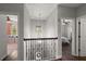 Second floor hallway overlooking bedrooms, with decorative wrought iron railings and elegant lighting at 12415 Hitching St, Odessa, FL 33556