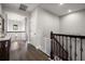 Upstairs hallway featuring wood floors, decorative railings, and a safety gate at the top of the stairs at 12415 Hitching St, Odessa, FL 33556