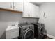 Functional laundry room with modern washer and dryer units and ample storage at 12415 Hitching St, Odessa, FL 33556