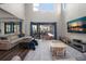 Open-concept living room featuring high ceilings, a large TV, and direct access to the outdoor patio at 12415 Hitching St, Odessa, FL 33556