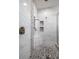 Modern shower with marble-look tile, a pebble floor, and built-in shower niches at 12415 Hitching St, Odessa, FL 33556