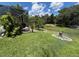 Landscaped backyard features a screened lanai overlooking a tranquil pond filled with lily pads and surrounding greenery at 1247 Gentilly Ln, Wesley Chapel, FL 33544
