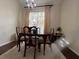 Bright dining room with a chandelier, wooden table and chairs, and large window at 1247 Gentilly Ln, Wesley Chapel, FL 33544
