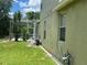Home exterior featuring a screened lanai, lush lawn, and an assortment of utility equipment at 1247 Gentilly Ln, Wesley Chapel, FL 33544