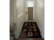 Hallway with decorative rug leading to bright door with covered window at 1247 Gentilly Ln, Wesley Chapel, FL 33544
