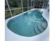 Inviting screened pool with steps and white pool deck and surrounding landscaping at 1247 Gentilly Ln, Wesley Chapel, FL 33544