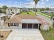 Backyard view featuring a patio and screened in porch, with a shed and driveway nearby in a close-up aerial at 13727 Gene Rossi Ave, Hudson, FL 34667
