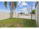 Fenced backyard features manicured lawn, a concrete patio, and a mature palm tree at 13727 Gene Rossi Ave, Hudson, FL 34667
