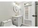 Updated powder room features gray vanity, white sink, gold accents, and adjacent storage at 13727 Gene Rossi Ave, Hudson, FL 34667