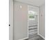 View of the gray hardwood flooring and area rug in the bedroom with large window at 13727 Gene Rossi Ave, Hudson, FL 34667