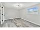 Light-filled bedroom with wood-look floors, neutral walls, and modern ceiling fixture at 13727 Gene Rossi Ave, Hudson, FL 34667