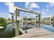 Waterfront residence featuring a private dock with boat lift, ideal for boating and enjoying waterfront living at 13727 Gene Rossi Ave, Hudson, FL 34667