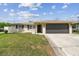 Charming single-story home with a well-manicured lawn and an attached two-car garage at 13727 Gene Rossi Ave, Hudson, FL 34667