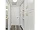 Hallway leading to updated powder room, featuring extra storage with gold accents at 13727 Gene Rossi Ave, Hudson, FL 34667