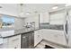 Bright kitchen with stainless appliances, granite counters, white cabinets and pendant lights at 13727 Gene Rossi Ave, Hudson, FL 34667