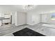 Bright open floor plan living room into kitchen with modern lighting, plank floors and neutral colors at 13727 Gene Rossi Ave, Hudson, FL 34667