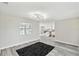 Bright living room with view into the kitchen, modern lighting, and gray plank floors at 13727 Gene Rossi Ave, Hudson, FL 34667