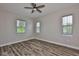 Spacious bedroom with wood-look floors, a ceiling fan, and multiple windows offering natural light and a calming view at 1410 E Curtis St # 2, Tampa, FL 33603