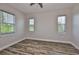 Bright bedroom with wood-look floors, a ceiling fan, and multiple windows offering natural light and serene outdoor views at 1410 E Curtis St # 2, Tampa, FL 33603