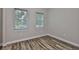 Bedroom with hardwood floors, light gray walls, and two large windows with blinds at 1410 E Curtis St # 2, Tampa, FL 33603