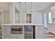 Kitchen with a wine cooler, microwave, white cabinets, quartz countertops, and hardwood floors at 1410 E Curtis St # 2, Tampa, FL 33603