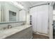 Bright bathroom featuring double sinks with a marble countertop, and a shower with a curtain at 16226 Carnoustie Dr, Odessa, FL 33556