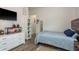 Comfortable bedroom featuring wood floors, a white dresser, and a mounted television at 16226 Carnoustie Dr, Odessa, FL 33556