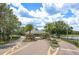 Inviting community entrance showcasing beautiful landscaping, a tranquil pond, and gated access at 16226 Carnoustie Dr, Odessa, FL 33556