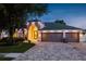 Charming single-story home featuring a well-manicured lawn, gray garage doors, and landscape lighting at 16226 Carnoustie Dr, Odessa, FL 33556