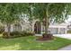 Charming single-story home featuring a well-manicured lawn and colorful flowerbeds in front at 16226 Carnoustie Dr, Odessa, FL 33556