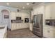 Well-lit kitchen with stainless steel appliances, ample counter space, and light wood-look tile flooring at 16226 Carnoustie Dr, Odessa, FL 33556