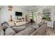Comfortable living room features a large gray couch, TV, and view of the pool at 16226 Carnoustie Dr, Odessa, FL 33556