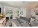 Bright living room with gray sectional couch, gray wood floors, and pool view at 16226 Carnoustie Dr, Odessa, FL 33556
