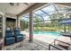 Screened in patio with comfortable seating overlooking the pool and golf course at 16226 Carnoustie Dr, Odessa, FL 33556
