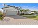 Charming home with a brick driveway, two-car garage, and palm trees in the front yard at 16423 Sapphire Point Dr, Lakewood Ranch, FL 34211
