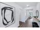 Bright hallway showcasing hardwood flooring and modern artwork on white walls at 16423 Sapphire Point Dr, Lakewood Ranch, FL 34211