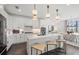Bright kitchen with white cabinets, a central island with stools, stainless appliances, and stylish pendant lighting above the island at 16423 Sapphire Point Dr, Lakewood Ranch, FL 34211