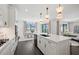 A modern kitchen with white cabinets, an island, and dining area with views of a lake and outdoor patio at 16423 Sapphire Point Dr, Lakewood Ranch, FL 34211